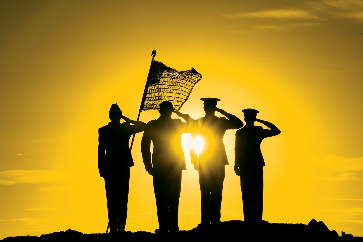 Silhouette of military personnel saluting with the American flag.