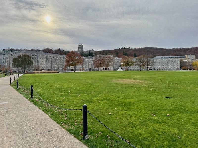 View of a large campus with buildings and a green field.
