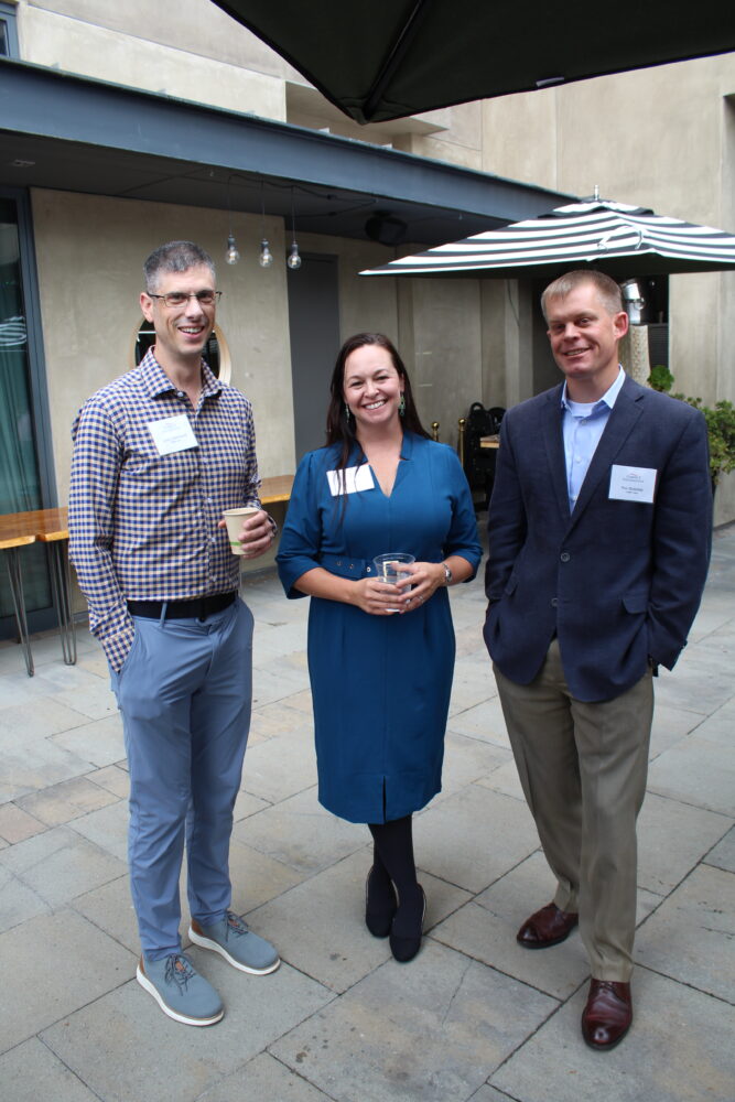 Three people posing at event